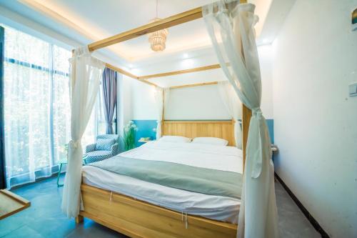 张家界Yixun Inn的一间卧室设有天蓬床和窗户。