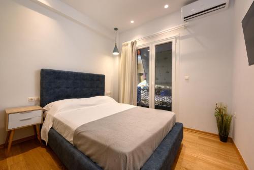 卡诺尼Kukos Apartment Corfu的一间卧室配有一张带蓝色床头板的床和窗户