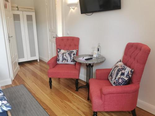 库克斯港德赫沃吉酒店的客厅配有两把椅子和一张桌子