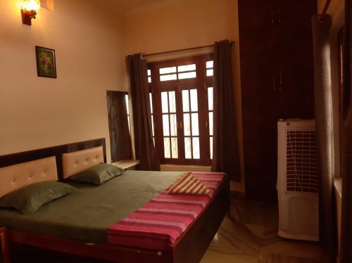 AyodhyaPAARIJAAT Homestay & Guesthouse的一间卧室配有一张床,设有窗户和门