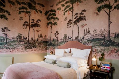 开普敦Dorp Hotel的卧室配有一张大床,墙上挂有绘画作品