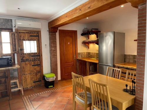 马贝拉Casa Calderón的厨房配有木桌和冰箱。