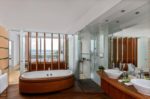 纳沙泰尔帕拉菲特酒店的一间带大浴缸和两个盥洗盆的浴室