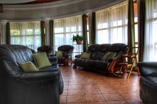 BükkzsércThe Mountain Cottage - Hegyi kuckó的客厅配有黑色皮革家具和窗户。