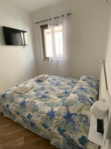 乌斯蒂卡Casa Gina e Pietro的一间卧室配有一张带蓝色和白色棉被的床