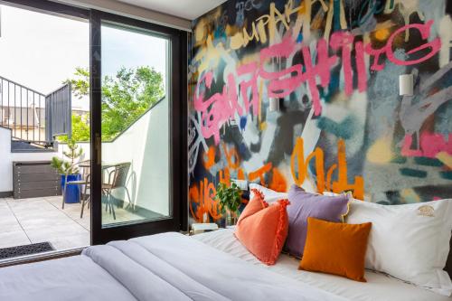 克拉科夫ArtSquare Fragola Apartments的一间卧室,墙上涂有涂鸦