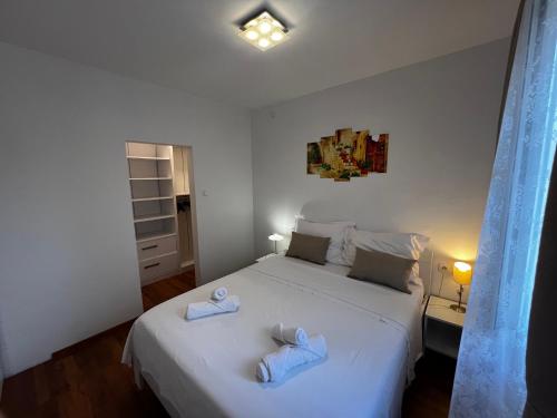 罗佐瓦克Apartments Village的卧室配有白色床和毛巾