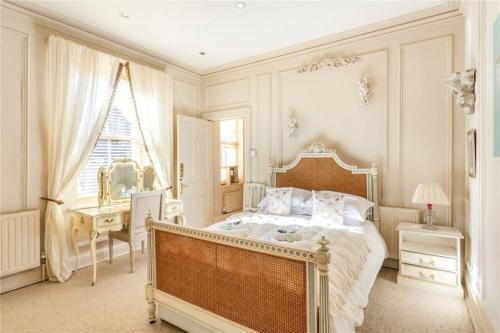 哈罗盖特The Stray View - Harrogate的一间卧室配有一张床、一张书桌和一个窗户。