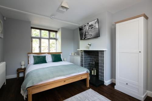 皇家滕布里奇韦尔斯Accommodation at Salomons Estate的一间卧室配有一张床和一个壁炉