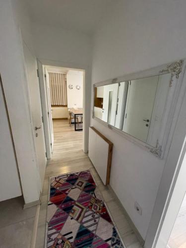 普里什蒂纳Plis Apartment II的走廊上设有镜子和地毯