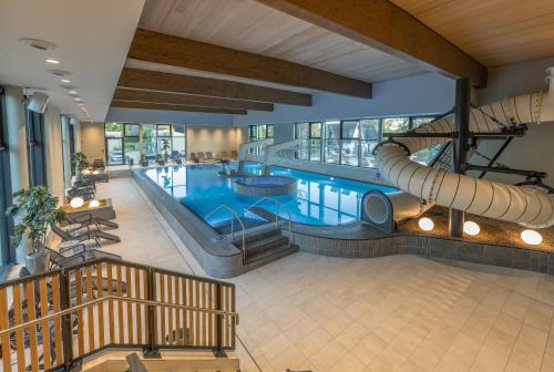 伦布鲁Marissa Resort的大楼内一个带滑梯的大型游泳池
