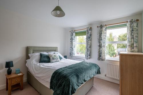 Addingham4 Bedroom House in Addingham Ilkley的一间卧室设有一张床和两个窗户。