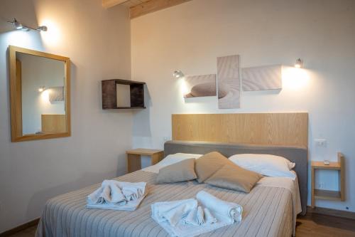 MartignanoB&B Alle Calende Greche的一间卧室配有带毛巾的床
