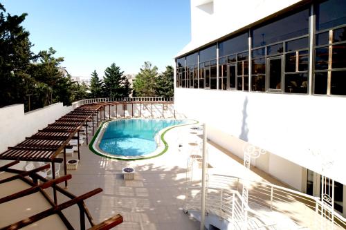 安曼Amman Paradise Hotel的建筑物一侧的游泳池