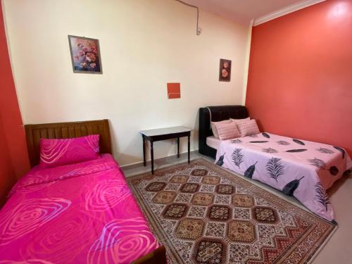 马兰MNOOR HOMESTAY的客房设有两张床和一张桌子,铺有地毯。