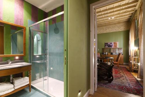 米兰Prestige Boutique Aparthotel - Montenapoleone的一间带玻璃淋浴和水槽的浴室