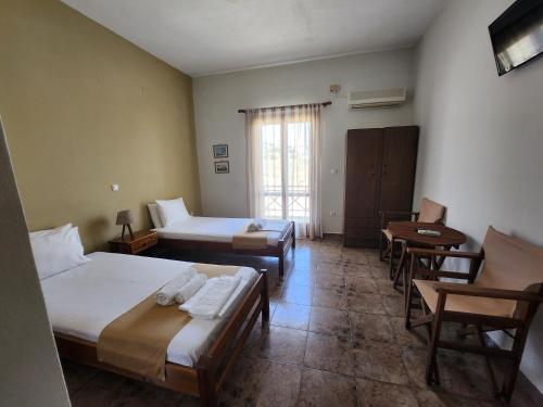 阿佐里姆诺斯Theodorou的一间设有两张床和一张桌子及椅子的房间