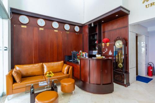胡志明市La Serena Hotel & Apartment的大堂设有长沙发和墙上的时钟