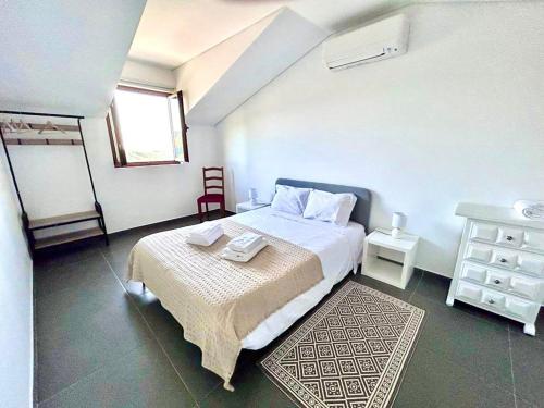 蒙丁-迪巴什图Casa Amarela - Mondim de Basto的一间卧室配有一张床、一张桌子和一个窗户。