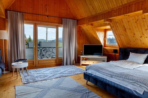 格利查尔DOMKI Sielsko Góra的一间卧室设有一张床、一台电视和一个窗口。