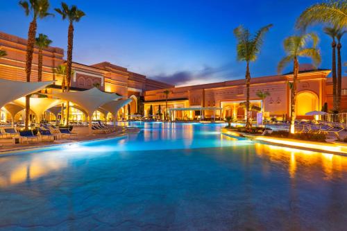 马拉喀什萨伏伊大酒店的一座棕榈树和建筑的大型游泳池