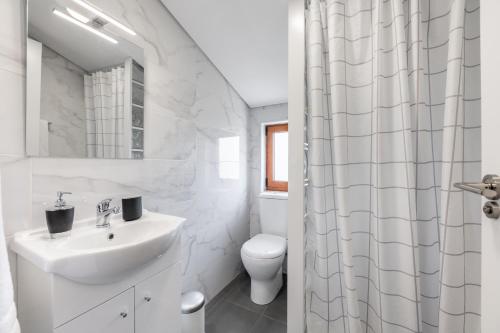 蒙丁-迪巴什图Casa Amarela - Mondim de Basto的白色的浴室设有水槽和卫生间。