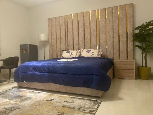 哈萨التوفيق للوحدات السكنية T1的一间卧室配有一张蓝色的床和一个大床头板