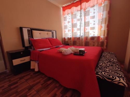 塔克纳Hotel hospedaje Odonovan的一间卧室配有红色的床和红色枕头