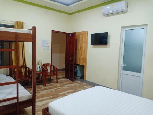 潘郎Đức Chính Hotel - Ninh Chu - Phan Rang的一间带两张双层床和电视的卧室