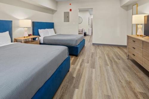 怀尔德伍德Seaport Suites的酒店客房带两张床和梳妆台