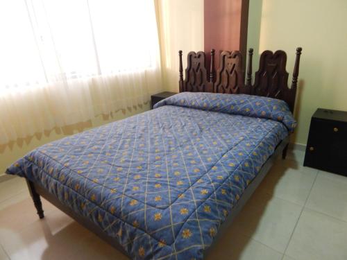 安巴托Ideal para descansar的一间卧室配有一张带蓝色棉被的床和窗户。