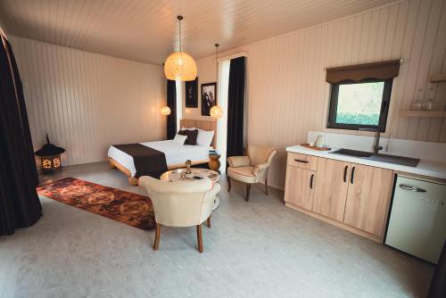 凯麦尔Cirali Hestia Lodge的酒店客房带一张床、一张桌子和椅子