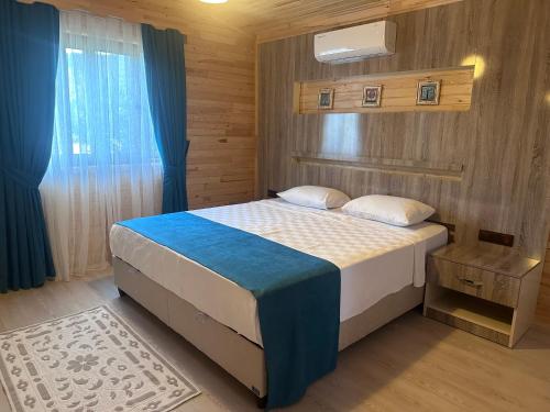 契拉勒儒雅为林公园度假屋的一间卧室配有一张带蓝色和白色棉被的床