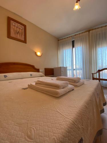 罗德里戈城Hostal Jose Mari的一间卧室配有两张带毛巾的床