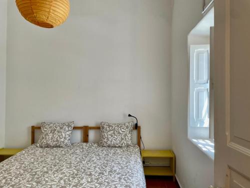 卡尔卡维洛斯茱莉亚帕蒂奥公寓的一间卧室配有带两个枕头的床和窗户