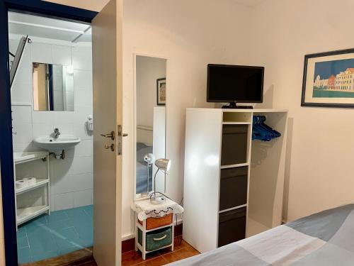 卡尔卡维洛斯茱莉亚帕蒂奥公寓的一间带电视的卧室和一间带水槽的浴室