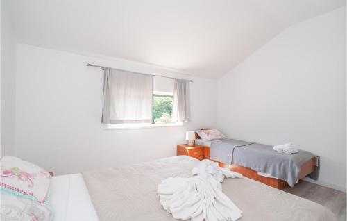 杜布罗夫尼克Awesome Apartment In Dubrovnik With Jacuzzi的白色的客房设有两张床和窗户。