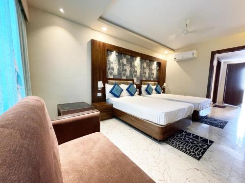 普里Hotel Ambika Palace ! Puri的一间卧室配有一张大床和一张沙发