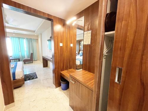 普里Hotel Ambika Palace ! Puri的一间带镜子的客厅和一间卧室