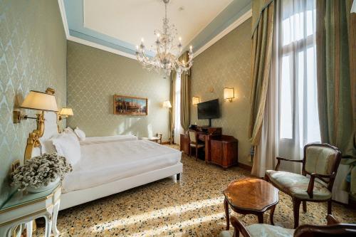 威尼斯哥伦比亚酒店的酒店客房,配有一张床和吊灯
