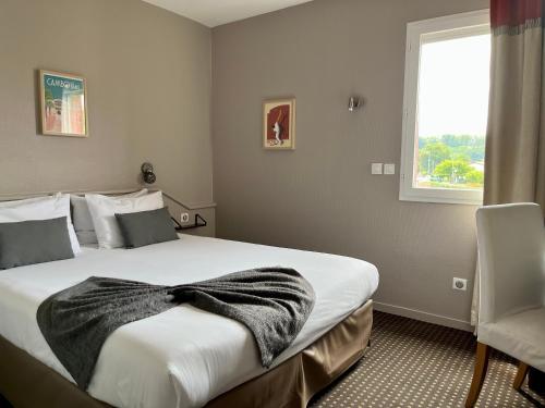 康博莱班Hôtel Ursula的一间卧室配有一张大床,床上有毯子