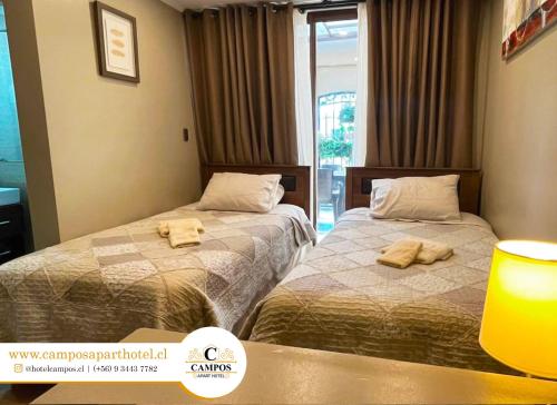 兰卡瓜Apart Hotel Campos Rancagua的两张位于酒店客房的床,配有毛巾