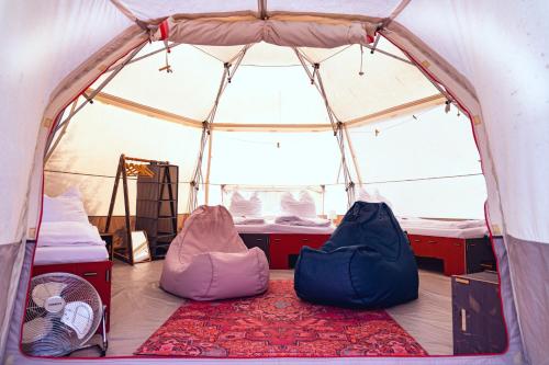 WesterwallDOMO CAMP Sylt - Glamping Camp的帐篷配有两张床和地毯