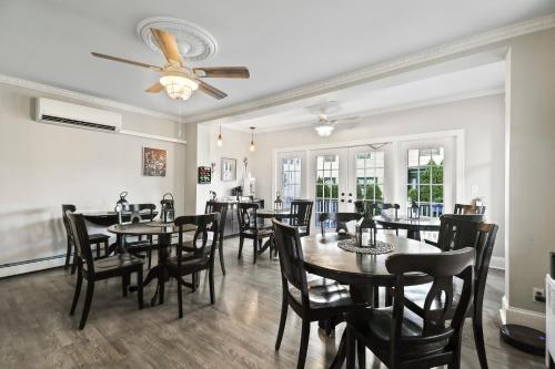 欧申格罗夫The Inn at Ocean Grove的一间带桌椅和吊扇的用餐室
