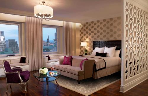蒙特利尔The Ritz-Carlton, Montreal的一间卧室配有一张床、一张沙发和一个窗口