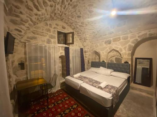 马尔丁Gılgamesh butik otel的石头间内一间卧室,配有一张床