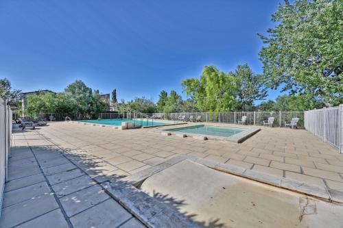 Saint-Saturnin-les-AvignonLE PETIT BONHEUR - PLACE PARKING PRIVEE - CLiM - TERRASSE - PISCINE PARTAGEE - PROCHE PARC SPIROU的庭院设有两个游泳池和围栏