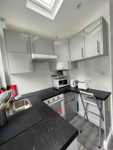 奇斯尔赫斯特Studio apartment/flat的厨房配有白色橱柜和黑色台面