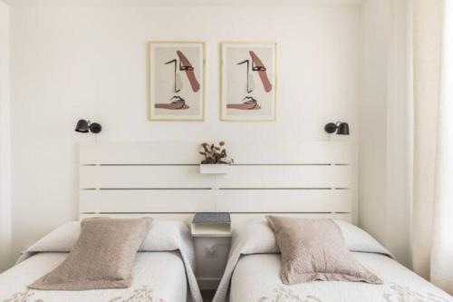 马德里Piso climatizado y parking的卧室配有两张床,墙上挂有两张照片