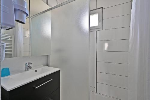 Saint-Saturnin-les-AvignonLE PETIT BONHEUR - PLACE PARKING PRIVEE - CLiM - TERRASSE - PISCINE PARTAGEE - PROCHE PARC SPIROU的白色的浴室设有水槽和镜子